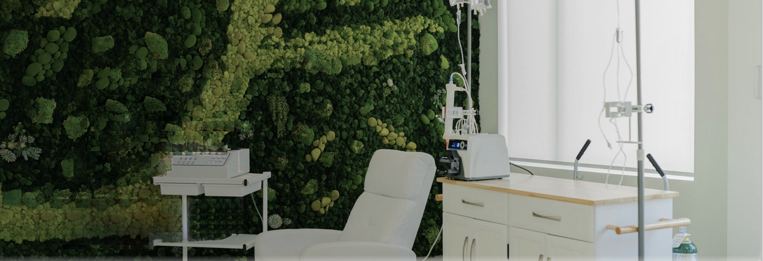 EBO2 treatment room — reclining chair, medical cart, IV pole and a bright window